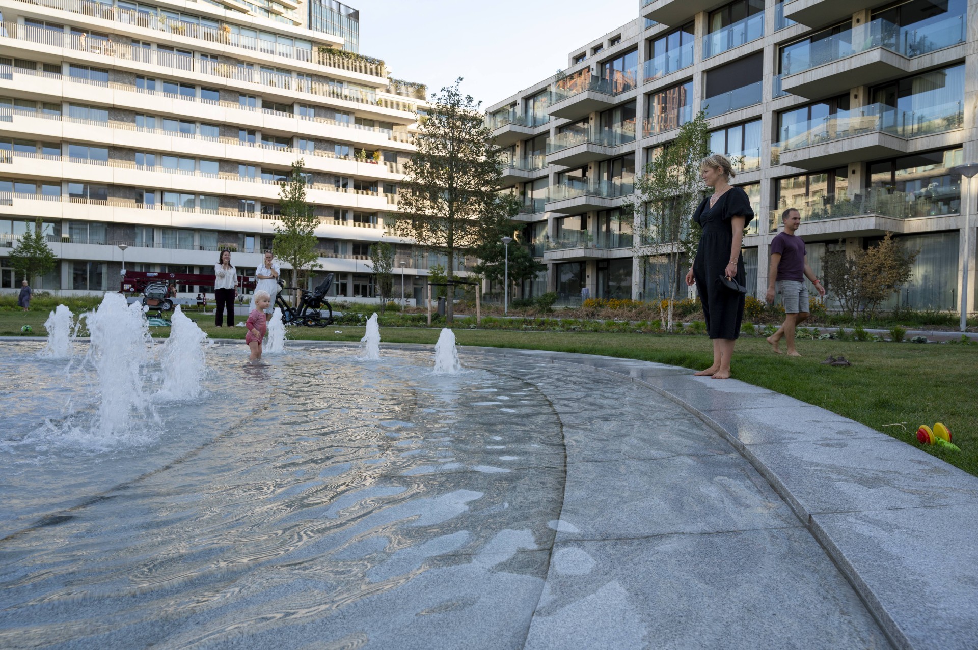 Kinderen spelen tussen de spuiters van de fontein op het Buurtplein in Overhoeks