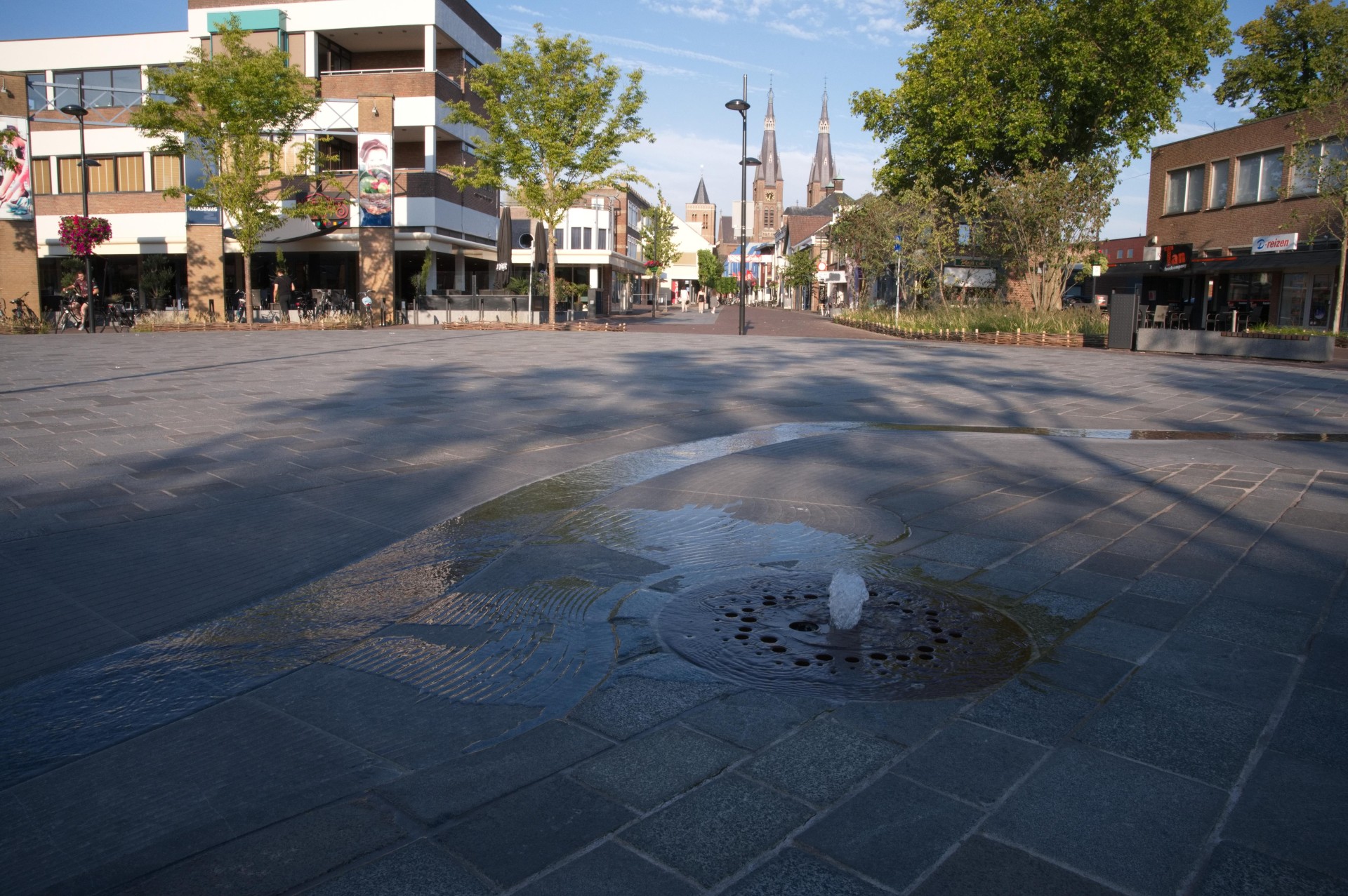 Louis Jansenplein in Cuijk met de Maasgoot in Belgisch hardsteen en zicht op de kerktoren