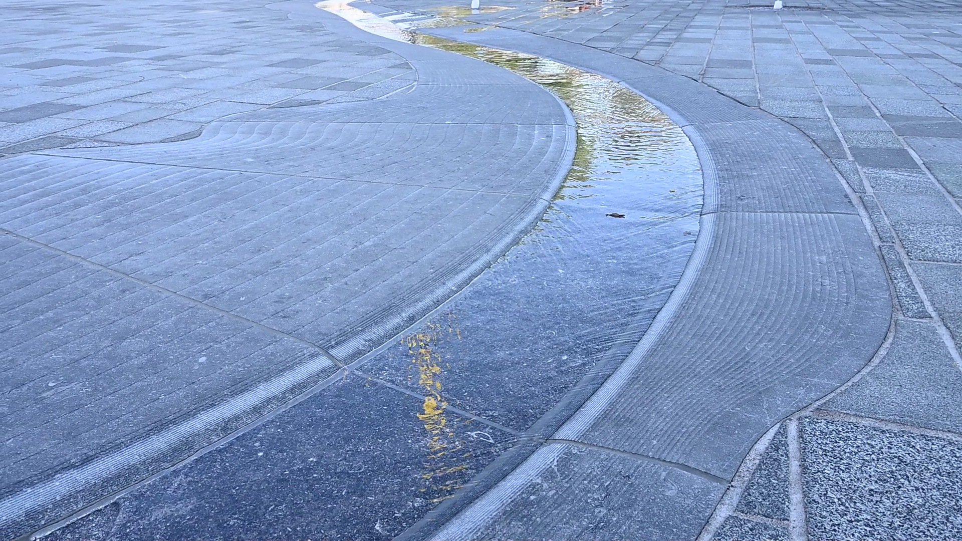 Cuijk waterloop hardsteen schemering relief Maasgoot natuursteen detail 22 Het Louis Jansenplein in Cuijk in het blauwe uur met blauw verlichte spuiters en de kerktorens