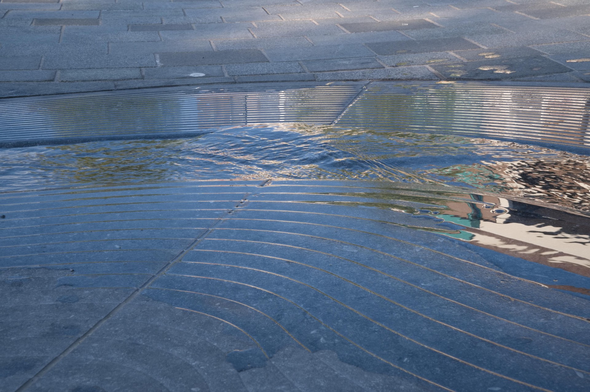 Reliëfsteen met waterspiegel waarin de gevels van Cuijk weerspiegelen