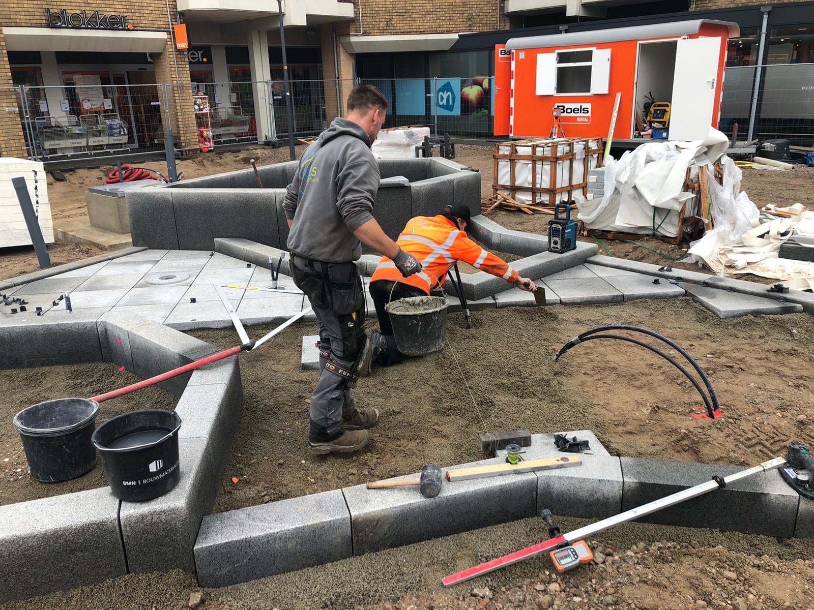 Werkers leggen het natuursteen van de ijsschotsen bij de ijsberenfontein in Dieren