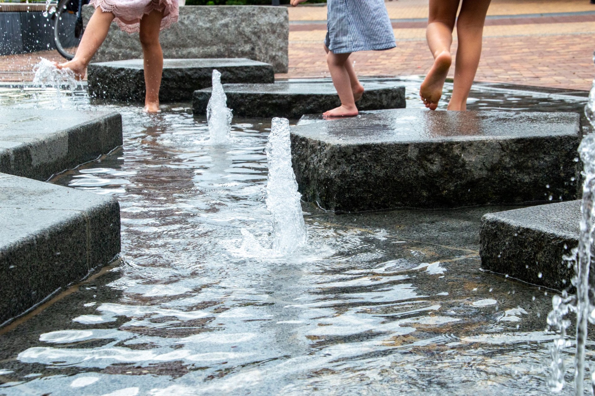 Kinderen spelen met water tussen de ijsschotsen en fonteintjes van de ijsberenfontein in Dieren