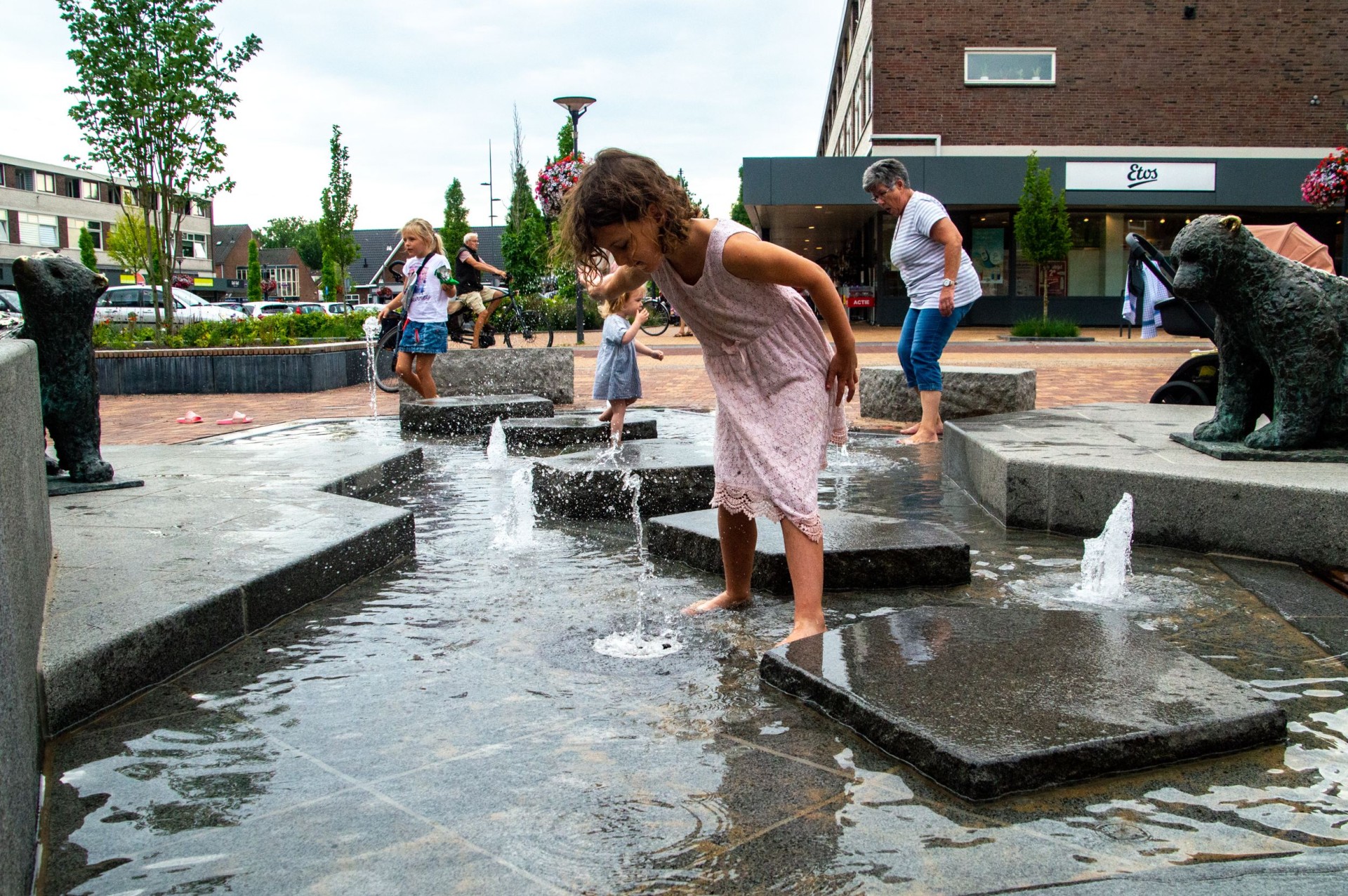 Meisje springt over de natuurstenen ijsschotsen van de ijsberenfontein in Dieren