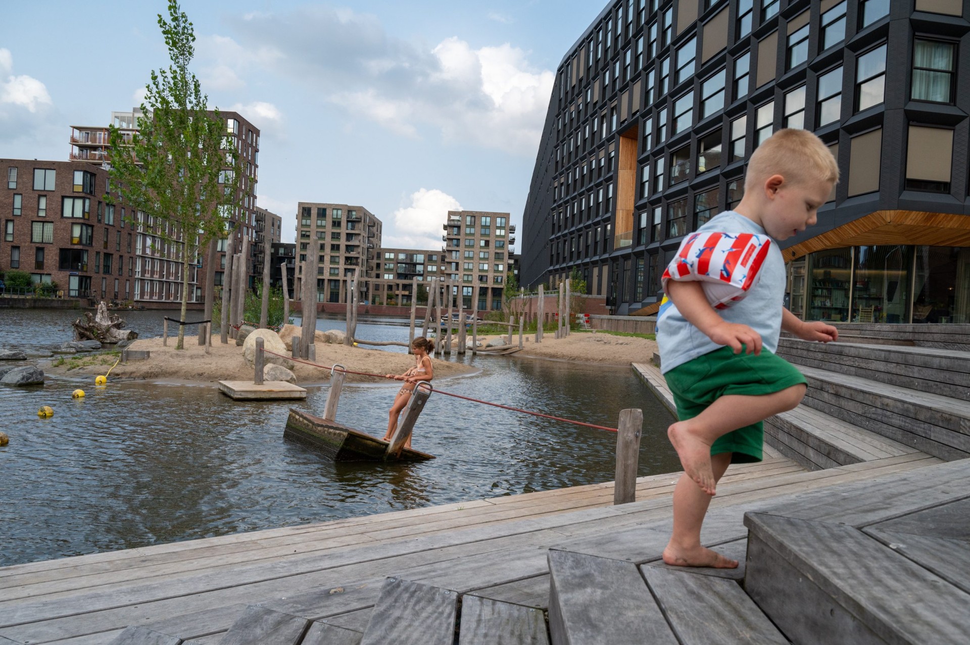 Peuter loopt over de houten trap en vlonders naast het water bij Jonas