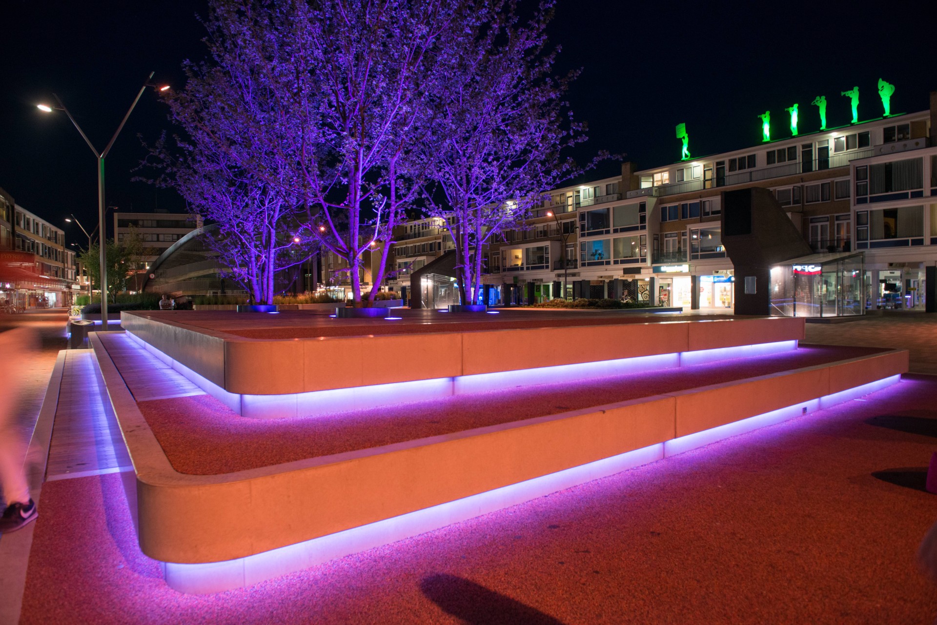 Paarse LED-lichtlijn langs betonnen zitbanden en hardhouten vlonders op de Nieuwe Markt in Roosendaal