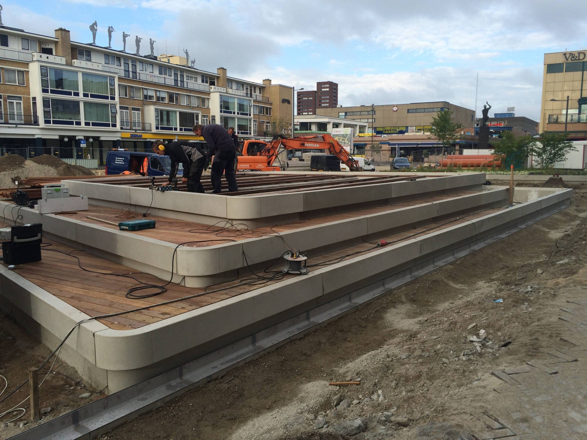 Aanleg van een betonband met hardhouten vlonders bij de groene eilanden op de Nieuwe Markt in Roosendaal