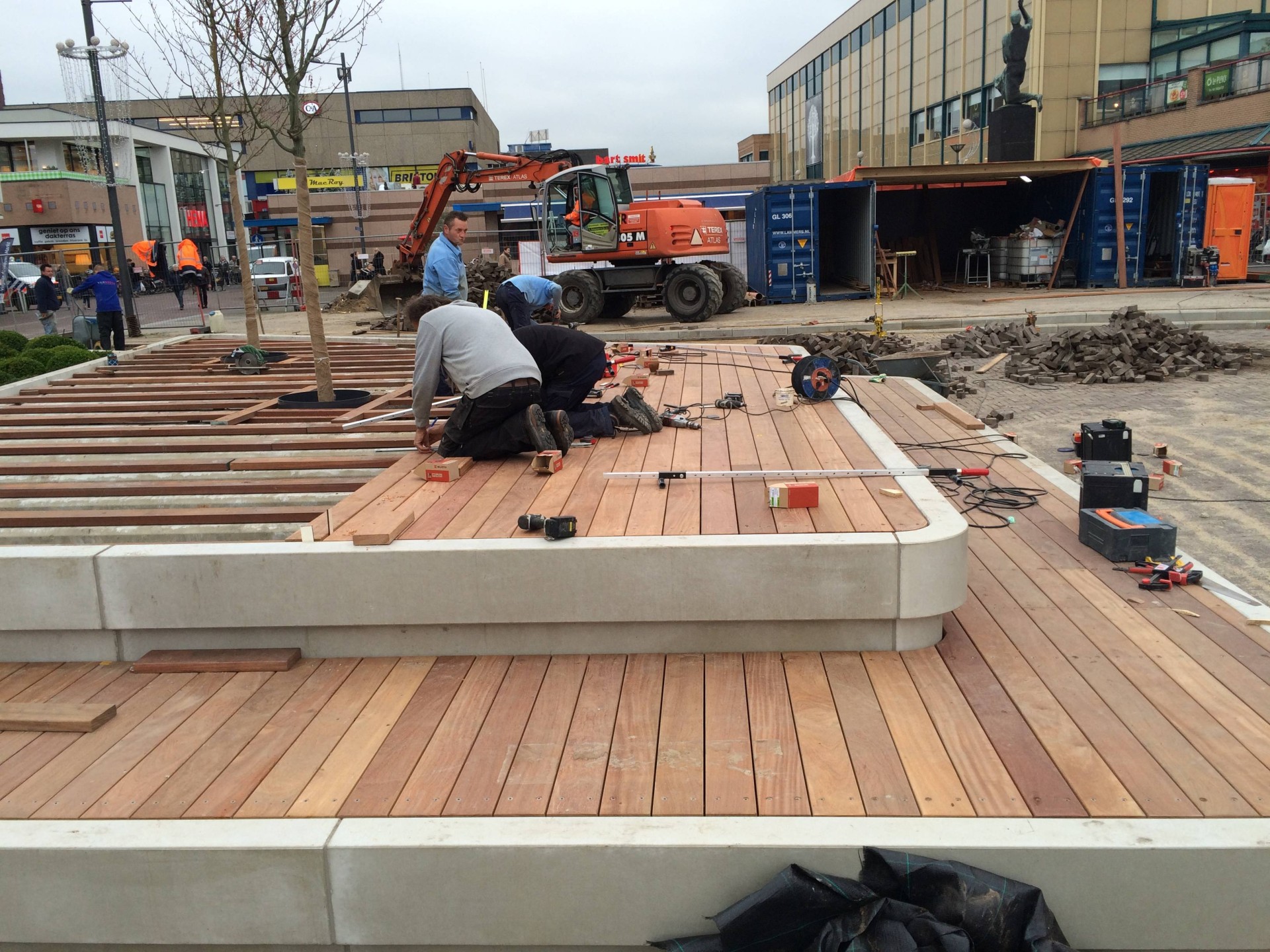 Hardhouten vlonders worden gemonteerd op de betonbanden van de Nieuwe Markt in Roosendaal