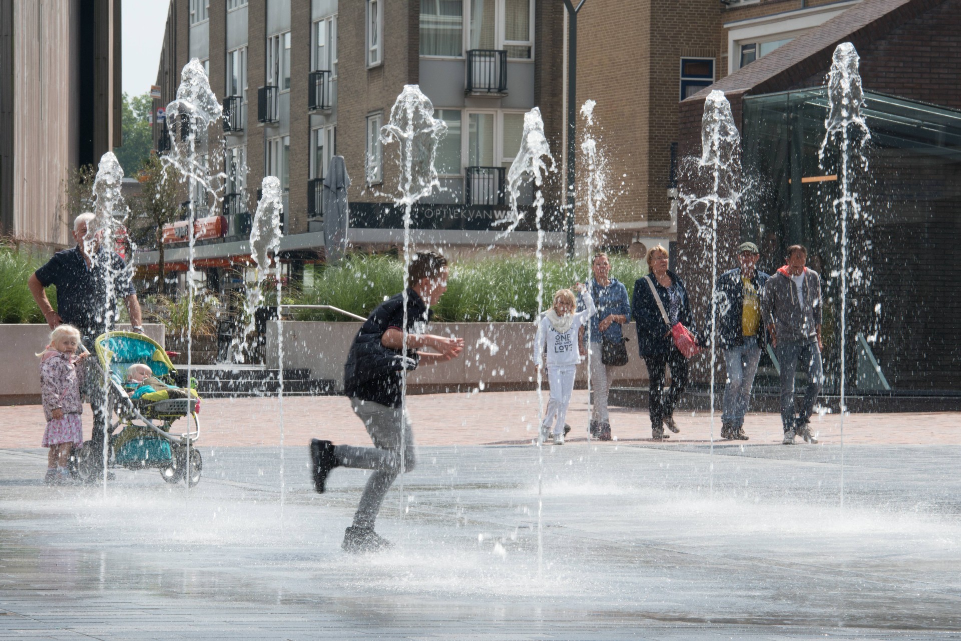 Kinderen rennen door de fonteinen van het waterplein op de Nieuwe Markt in Roosendaal