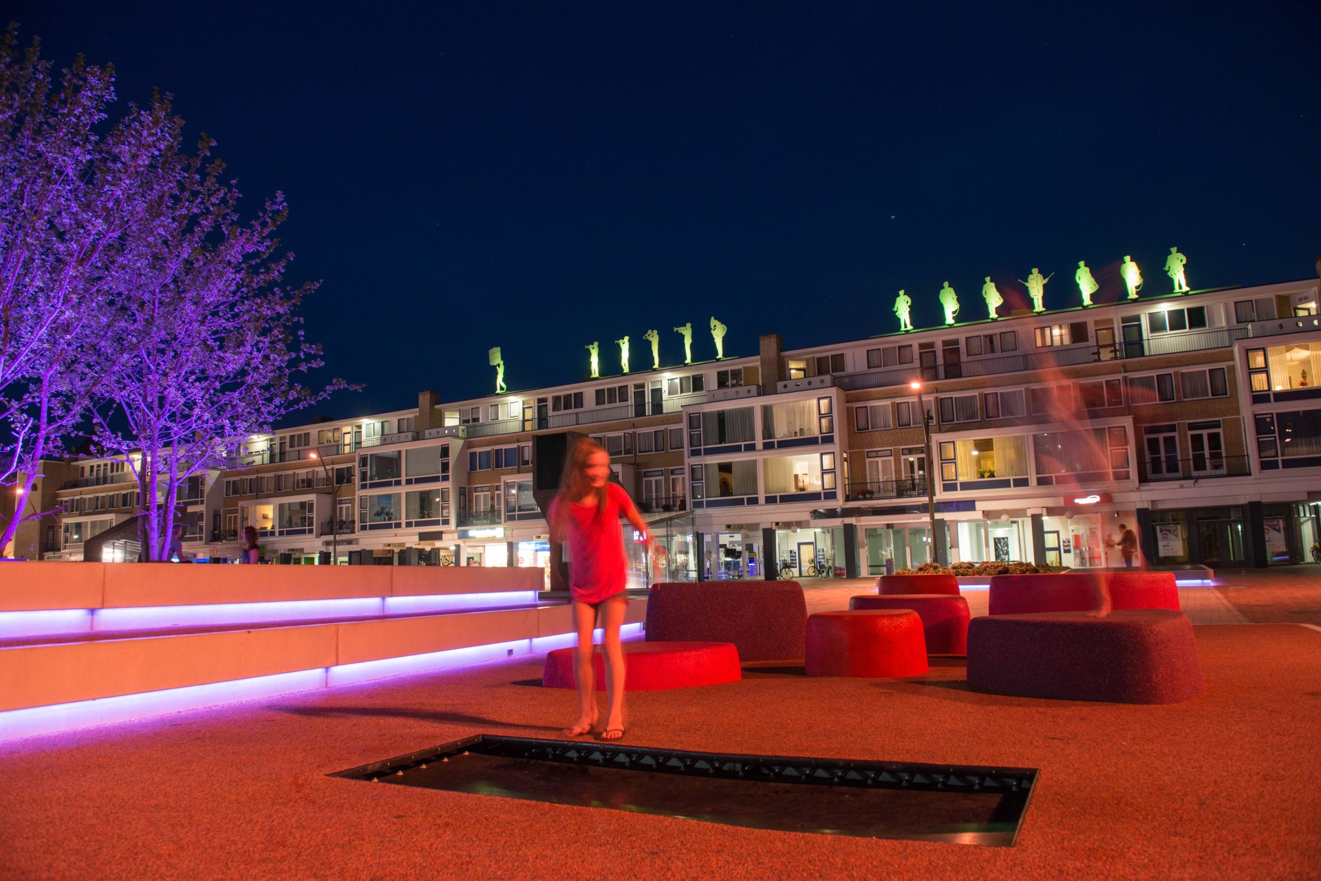Meisje speelt in de avond bij LED-verlichte betonbanken en speelelementen op de Nieuwe Markt in Roosendaal