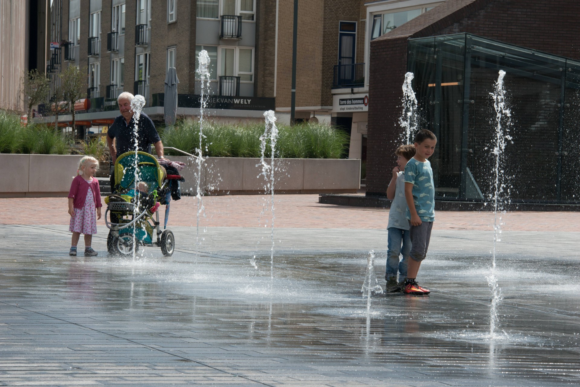 Peuters en een opa bij de fonteinen op de Nieuwe Markt in Roosendaal